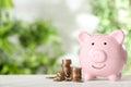 Piggy bank and coins on white wooden table. Money savings Royalty Free Stock Photo