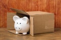 Piggy bank coming out of cardboard box Royalty Free Stock Photo