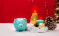 Piggy bank decorated in Christmas celebration theme on white table reb background with copy-space, family spent time together in Royalty Free Stock Photo