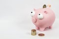 Piggy Bank With a Dropping Pound Coin and a Stack of Pound Coins Royalty Free Stock Photo