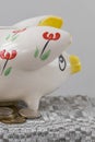 Piggy bank in the form of a painted pig. A handful of coins