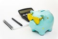 Piggy Bank with glasses a green color with a Notepad and calculator. The concept of saving money, Finance, and budget Royalty Free Stock Photo