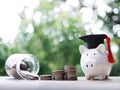 Piggy bank with graduation hat, Glass bottle and stack of coins. The concept of saving money for education, student loan, Royalty Free Stock Photo