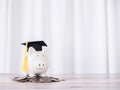 Piggy bank with graduation hat on stack of coins. The concept of saving money for education, student loan, scholarship, tuition Royalty Free Stock Photo