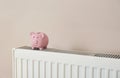 Piggy bank on heating radiator Royalty Free Stock Photo