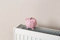 Piggy bank on heating radiator Royalty Free Stock Photo