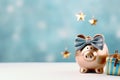 A piggy bank with holiday accessoires on a pastel background with copyspace