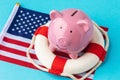 Piggy bank, lifebuoy and flag on a blue background, the concept of saving the American economy Royalty Free Stock Photo