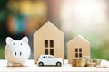 Piggy bank, Little toy car, money coins stacked on each other in different positions, house in paper model on the wooden table. Cr Royalty Free Stock Photo