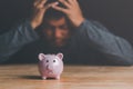 piggy bank and man with uneasiness,unsolvable financial problem concept,unemployment, poverty, unpaid debts,business loss,