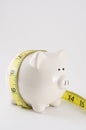 Piggy bank with measure tape Royalty Free Stock Photo