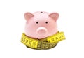 Piggy bank with measure tape on white background Royalty Free Stock Photo