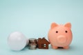 Piggy bank with money banknote,led light bulb and house figure. Power saving concept Royalty Free Stock Photo