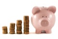 Piggy bank next to 'graph' of coins Royalty Free Stock Photo