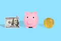 . Piggy bank, one hundred dollar bill and bitcoin on a bright blue background. The concept of safe storage of financial savings Royalty Free Stock Photo