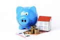 piggy bank and paper house and key with coins stack