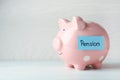 Piggy bank and paper with word PENSION on table Royalty Free Stock Photo