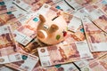 Piggy bank in a pile of russian five thousand banknotes