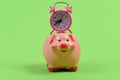 Piggy bank with retro alarm clock. Time is money concept. Royalty Free Stock Photo