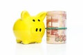 Piggy bank and a roll of money worth 5,000 rubles. Finance and savings. White background Royalty Free Stock Photo