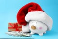 Piggy bank with Santa hat, dollar banknotes and gift box Royalty Free Stock Photo
