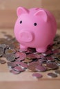 Piggy bank sitting on top of a pile a of coins Royalty Free Stock Photo