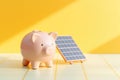 A piggy bank with a solar panel. Saving costs of electricity, green transition concept Royalty Free Stock Photo