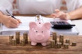 Piggy Bank And Stacked Coins On Wooden Desk Royalty Free Stock Photo