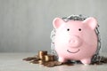 Piggy bank with steel chain and coins on table, space for text. Money safety concept