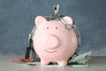 Piggy bank with steel chain, padlock and banknotes on grey marble table. Money safety concept Royalty Free Stock Photo