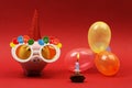 Piggy bank with sunglasses Happy birthday, party hat and multicolored party balloons on red background Royalty Free Stock Photo