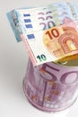 Piggy bank with ten and twenty euro banknotes, seen from above Royalty Free Stock Photo