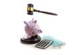 Piggy bank upside down under the judge gavel, calculator and surgical face mask, insolvent due to corona crisis and confiscation