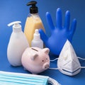 Piggy bank and various personal protective equipment on a blue background