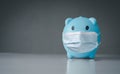 Piggy bank wears a mask to prevent the spread of coronavirus. That affect the economy Global finance and security.