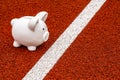 Piggy bank on the white starting line on the race track Royalty Free Stock Photo