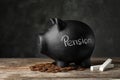 Piggy bank with word PENSION, chalk and coins on table Royalty Free Stock Photo