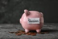 Piggy bank with word PENSION and coins on table Royalty Free Stock Photo