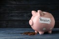 Piggy bank with word PENSION and coins on table Royalty Free Stock Photo