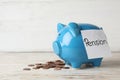 Piggy bank with word PENSION and coins on table Royalty Free Stock Photo