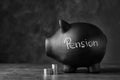 Piggy bank with word PENSION and coins on table Royalty Free Stock Photo