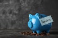 Piggy bank with word PENSION and coins on table Royalty Free Stock Photo