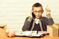 piggy pig bank holding and speaking on cell phone on white brick wall background, copy space. young cute businessboy Royalty Free Stock Photo