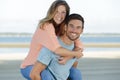 Piggyback couple on shore Royalty Free Stock Photo