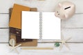 Piggybank on blank white notebook with passports and a pencil on