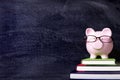 Piggybank with glasses and blackboard, copy space, back to school concept Royalty Free Stock Photo