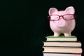 Piggybank wearing glasses with blackboard background