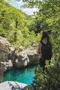 Pigtailed backpacking woman, standing in dense Pyrenees forest