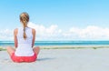 Pigtailed girl sitting on the beach.