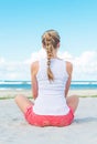 Pigtailed girl sitting on the beach.